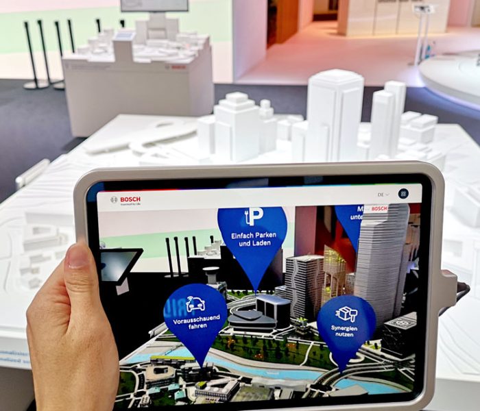 Augmented Reality Anwendung auf einem Tablet, bei dem mit Objekterkennung eines Weissmodells einer Stadt eine virtuelle Stad angezeigt wird