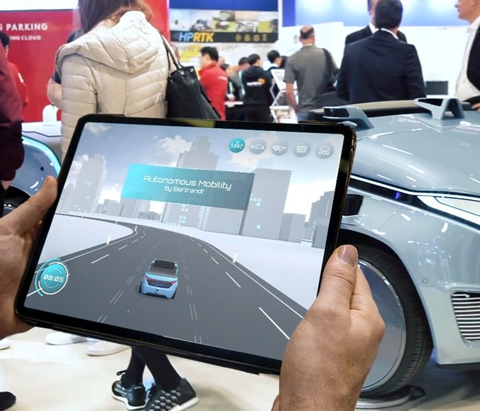 Mann spielt ein interaktives 3D-Game mit einem virtuellen digitalen Zwilling eines concept-car auf einem Messestand zur Erhöhung der awareness für die Marke bertrand